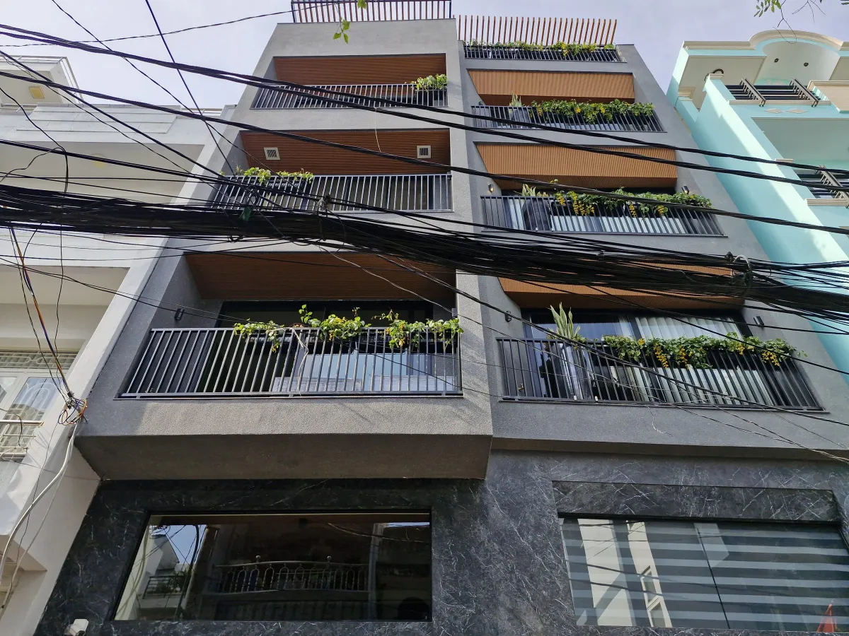 Mặt tiền MXT House với ban công cây xanh